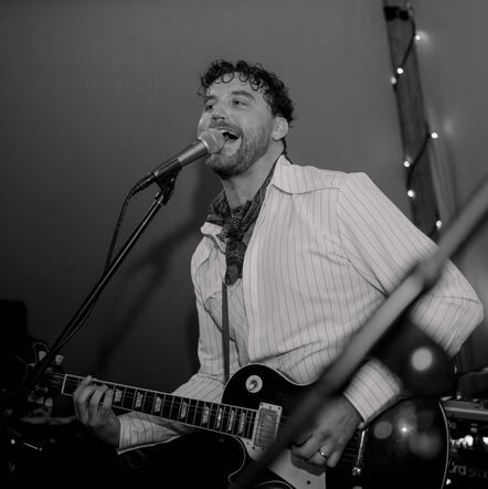 The guitarist serenading the crowd at a London function